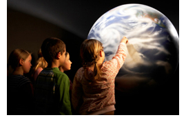 Image of some students pointing to a map of the Earth.