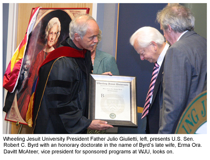 Image of Erma Ora Byrd that reads - Wheeling Jesuit University President Father Julio Giulietti, left, presents U.S. Sen. Robert C. Byrd with an honorary doctorate in the name of Byrd late wife, Erma Ora. Davitt McAteer, vice president for sponsored programs at WJU, looks on.