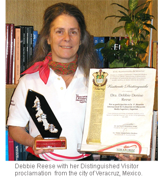 Image of Debbie Reese holding Distinguished Visitor proclamation.